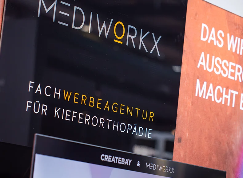 MEDIWORKX Messestand mit Team am Beratungstisch – spezialisierte Werbeagentur für Kieferorthopädie
