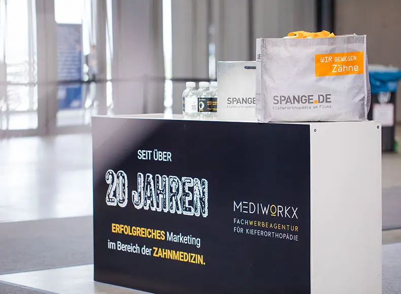 MEDIWORKX Messestand mit Team am Beratungstisch – spezialisierte Werbeagentur für Kieferorthopädie